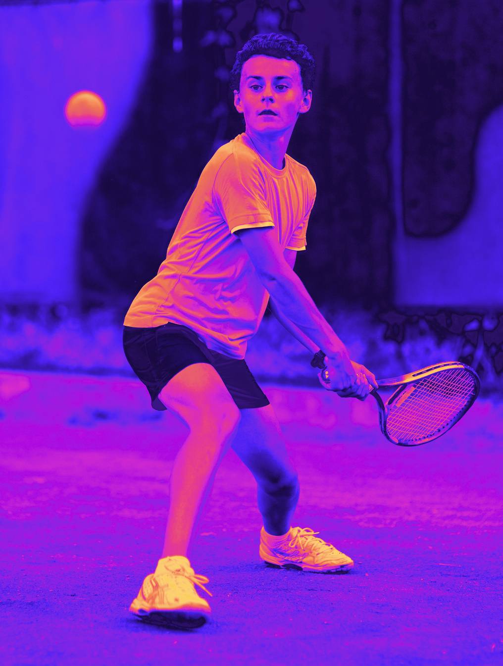 A young tennis player preparing to return a ball